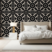 Monochrome circle wallpaper behind a beige bed with a gold lamp and marble nightstand GD12506