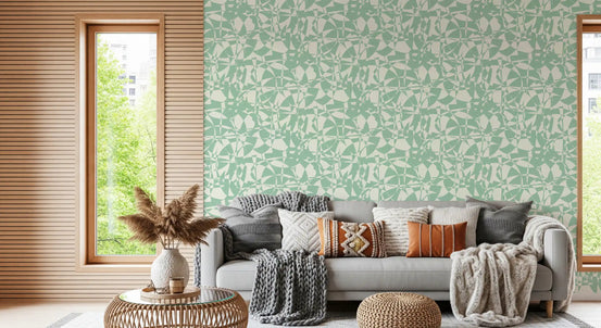 Sage green abstract wallpaper behind a grey sofa with pampas grass and wood blinds GD12618