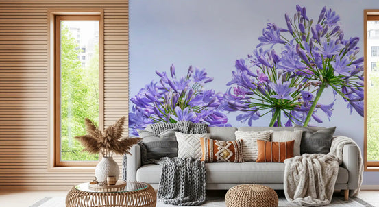 Blue lily cluster wall mural behind a grey sofa with earthy cushions and pampas grass GD12806