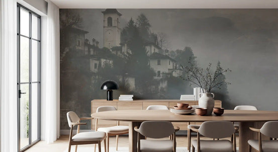 Foggy hillside village mural in a dining room with round wood table and sideboard GD12893