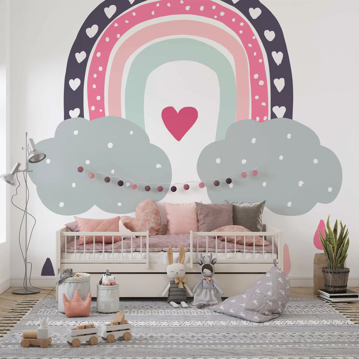 Heart-filled rainbow nursery mural above a pink daybed with dolls and toys GD12898