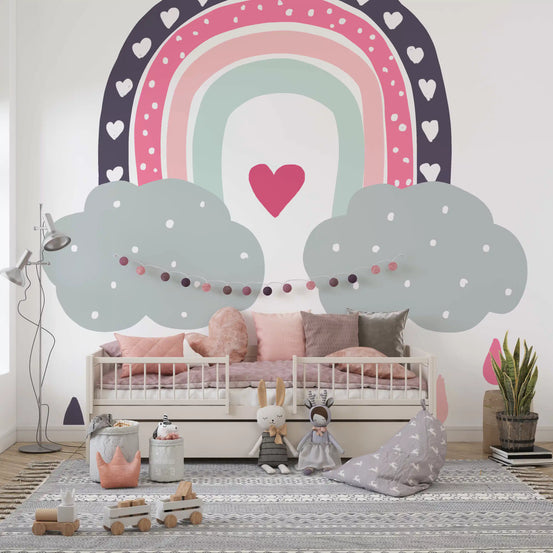 Heart-filled rainbow nursery mural above a pink daybed with dolls and toys GD12898