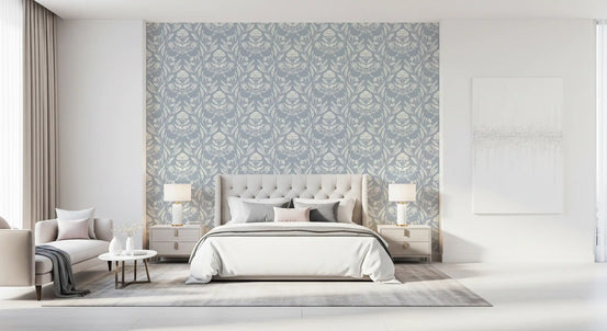 Block print damask floral wallpaper behind an upholstered bed with matching lamps GD12976