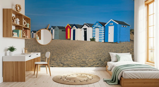 Beach wallpaper of seaside huts on a bedroom wall beside a white vanity GD13028