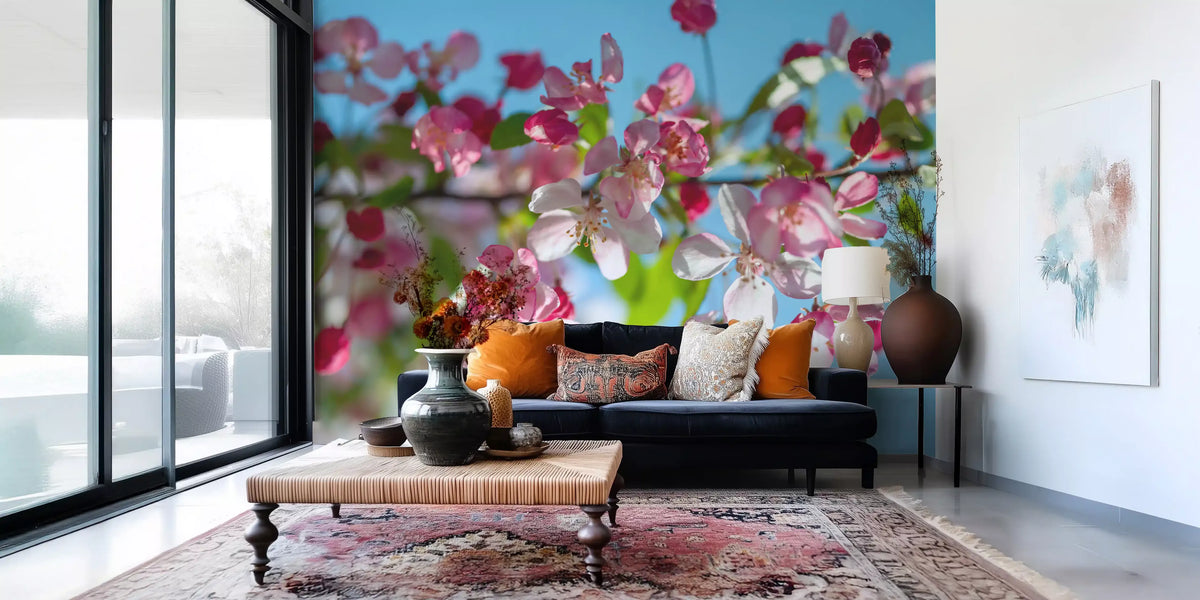 Cherry blossom wallpaper in a lounge with a navy sofa and orange cushions GD13035