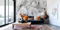 Black and white wallpaper of roses behind a navy sofa and patterned rug GD13038