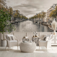 City wallpaper of a canal behind white cane chairs in a bright room GD13043