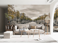 Canal autumn mural behind a pale sofa and nesting tables in a lounge GD13043