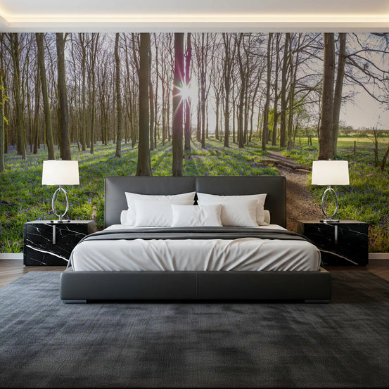 Forest wallpaper mural behind a dark gray bed with black marble nightstands and white lamps GD13389