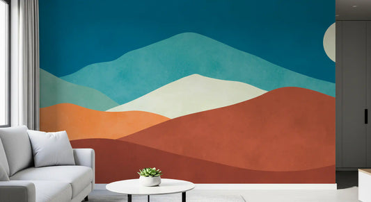 Light gray sofa and round white side table in front of a rust and teal desert hill mural GD13774