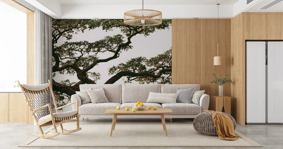 Tree wallpaper mural behind a gray sofa and wooden rocking chair in a bright living room GD13961