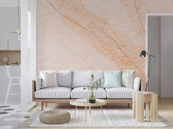 Peach marble wallpaper behind a white sofa, round wood coffee table and woven pouf GD14025