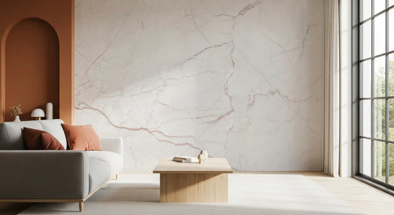 Blush marble wallpaper behind a gray sofa with rust cushions and a terracotta arch GD14072