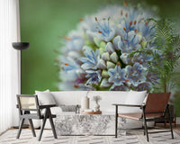 Living room with a white sofa, cane chair and marble table on an allium flower mural GD14202