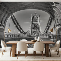 London wallpaper behind a long wood dining table, cream chairs and brass lamps GD14209