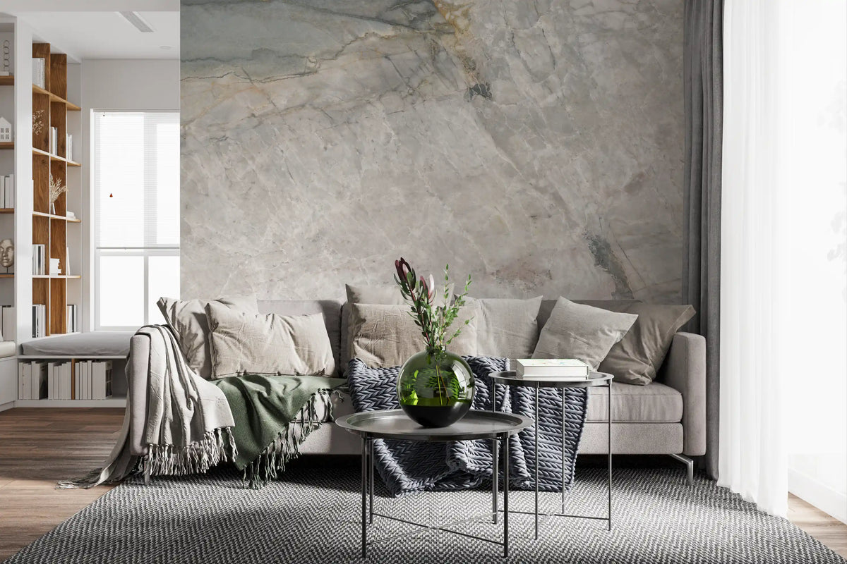 Stone effect mural behind a gray sofa with green throw and round black side tables GD14211
