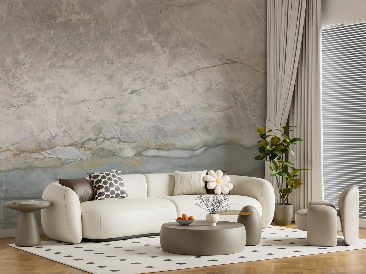 Marble wallpaper behind a cream curved sofa and round pouf on a dotted rug GD14215