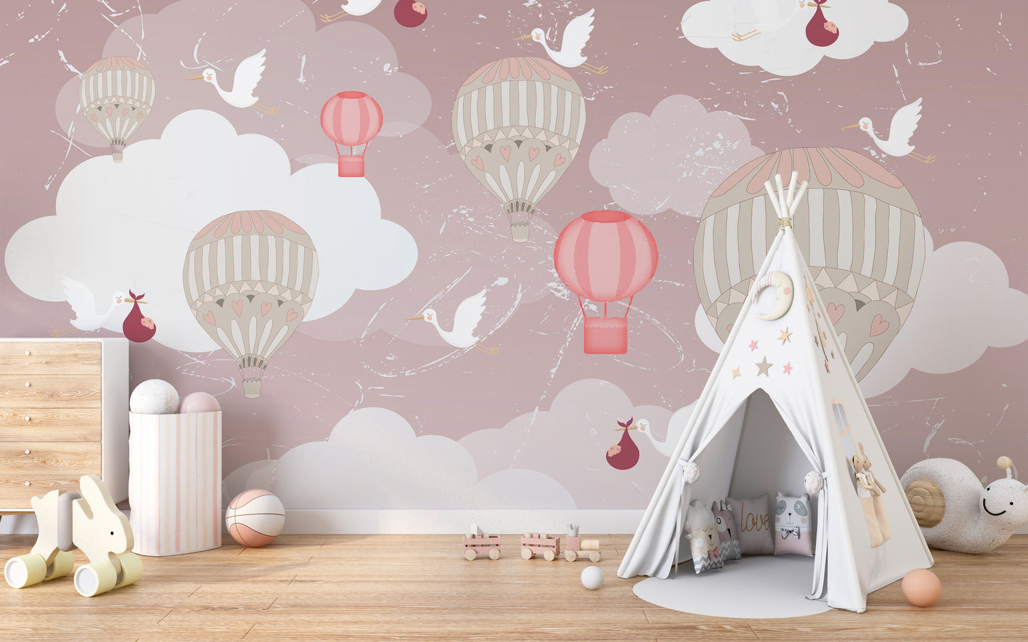 3D Hot Air Balloon wallpaper mural in pink with storks and balloons behind a white teepee tent in a nursery