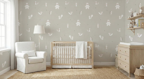 White Color Forest Animals wallpaper in pale grey-green behind a light wood crib and white nursery armchair