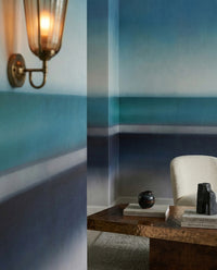 Hazy teal seascape wall mural fills a coastal-feel lounge