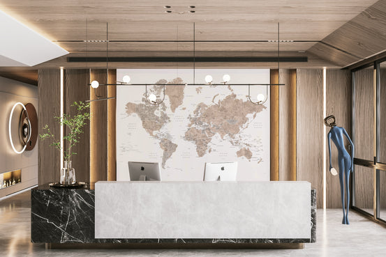 Abey watercolor world map mural in sepia tones behind a marble reception desk with two iMacs in a wood-panelled lobby