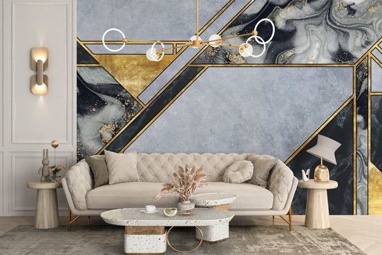 Abstract Gold Geometric Marble wallpaper mural in blue and gold behind a beige tufted sofa in a bright living room