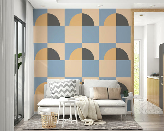 Abstract Sun and Sky wallpaper behind a white sofa with grey chevron cushions and a knit throw, kitchen beyond