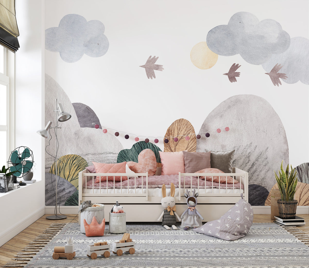 Abstract watercolor landscape wallpaper mural in muted hills and clouds behind a pink toddler daybed in a sunny nursery