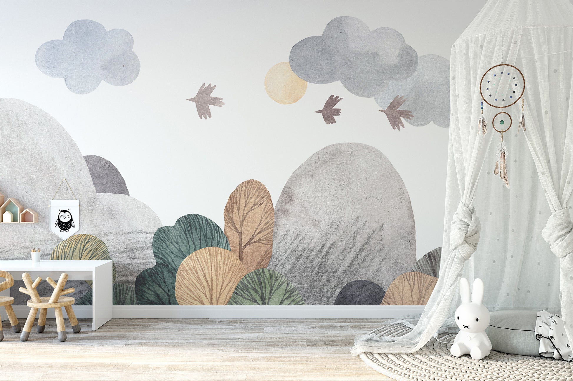 Abstract watercolor landscape wallpaper mural in grey and green over a white desk and stool in a nursery with bunny canopy