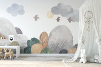 Abstract watercolor landscape wallpaper mural in grey and green over a white desk and stool in a nursery with bunny canopy