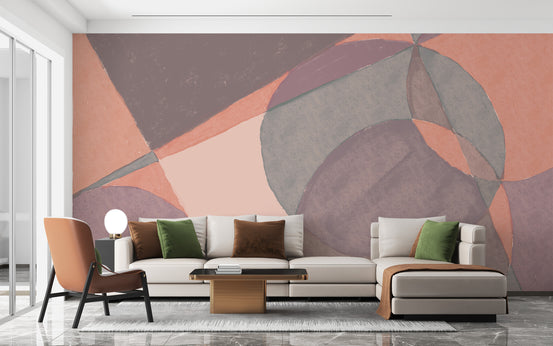 Watercolor Illustration wallpaper mural in peach and mauve geometric shapes behind a cream sofa and terracotta chair in a living room
