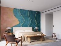 Abstract Wave with Gold Line wallpaper mural in teal and coral above an upholstered bed and wooden bench in a bedroom