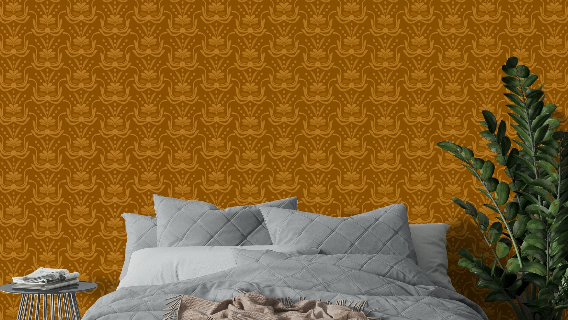 Amber Hues wallpaper in warm mustard tones above a grey quilted bed beside a green ZZ plant in a bedroom