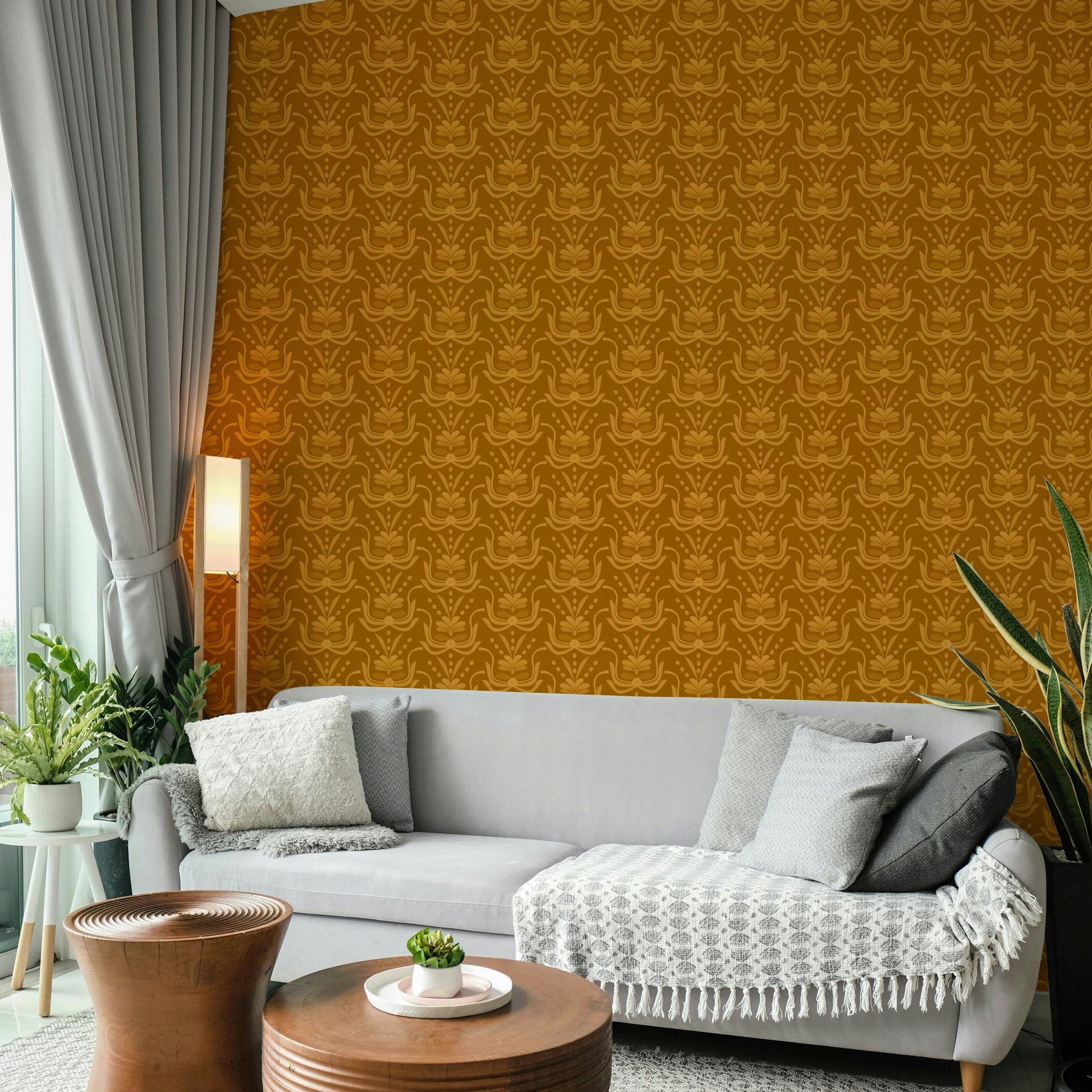 Amber Hues wallpaper in warm amber behind a grey sofa with wood drum tables in a cozy living room