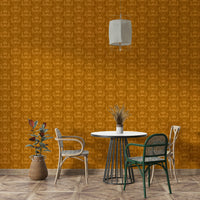 Amber Hues wallpaper in ochre damask behind a round dining table with woven chairs and a pendant light
