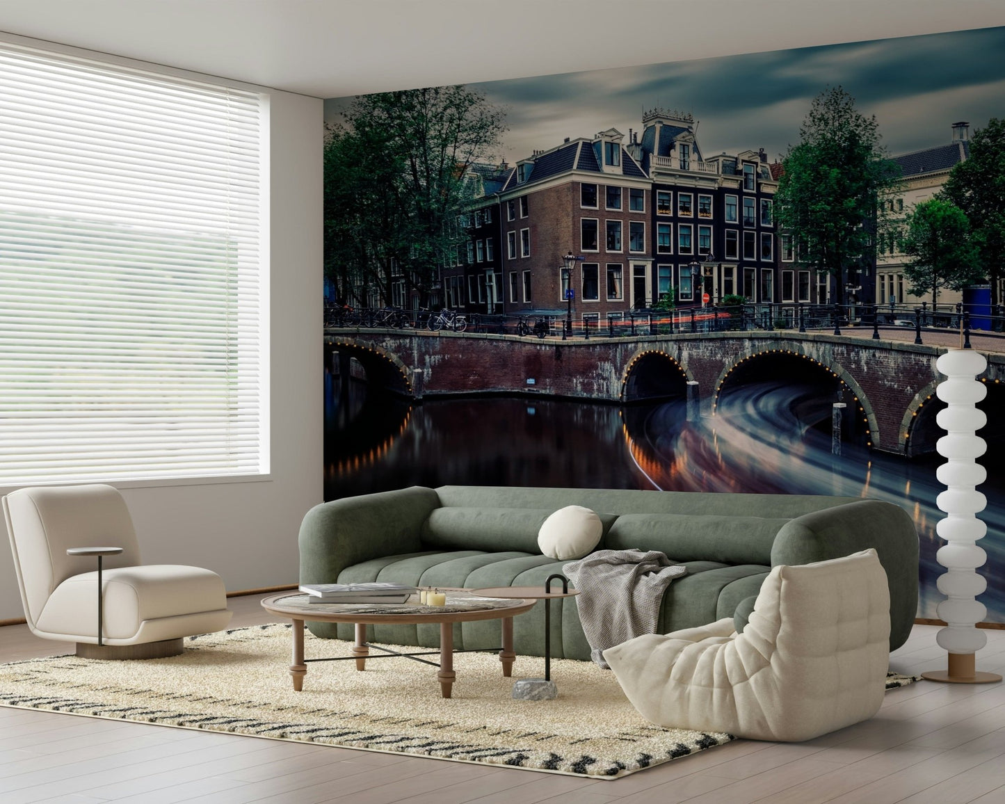 Amsterdam Canal Dreams wallpaper mural of the lit canal bridges behind a green sofa and bouclé pouf in a living room