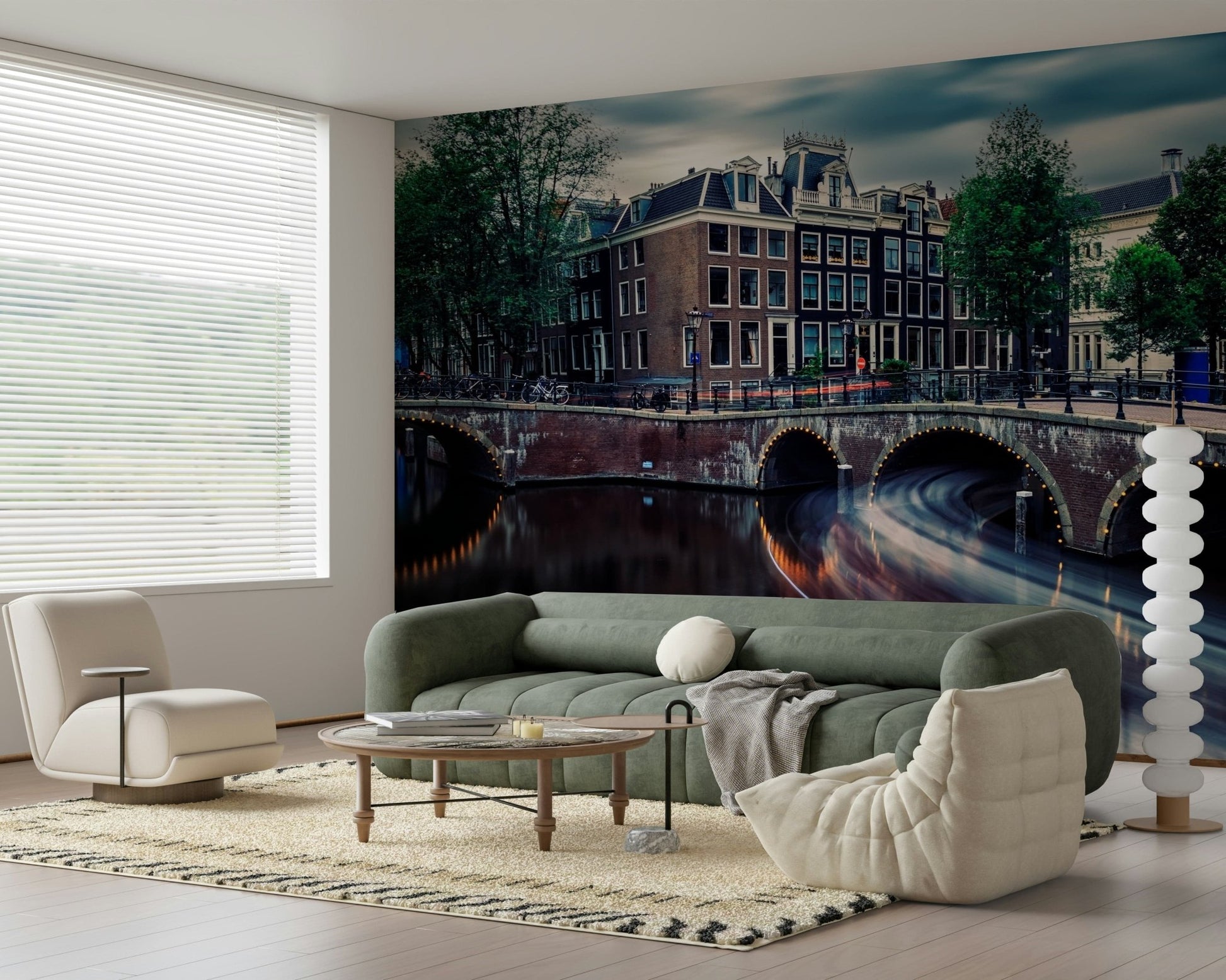 Amsterdam Canal Dreams wallpaper mural of the lit canal bridges behind a green sofa and bouclé pouf in a living room
