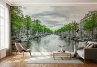 Amsterdam Canal Serenity wallpaper mural of a green-trimmed canal behind a gray sofa and wood chair in a living room