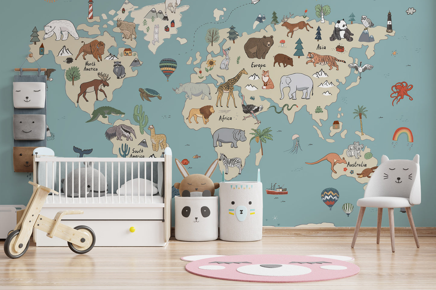 Animal Adventure Atlas wallpaper mural on a teal world map wall above a white crib and animal-face bins in a nursery