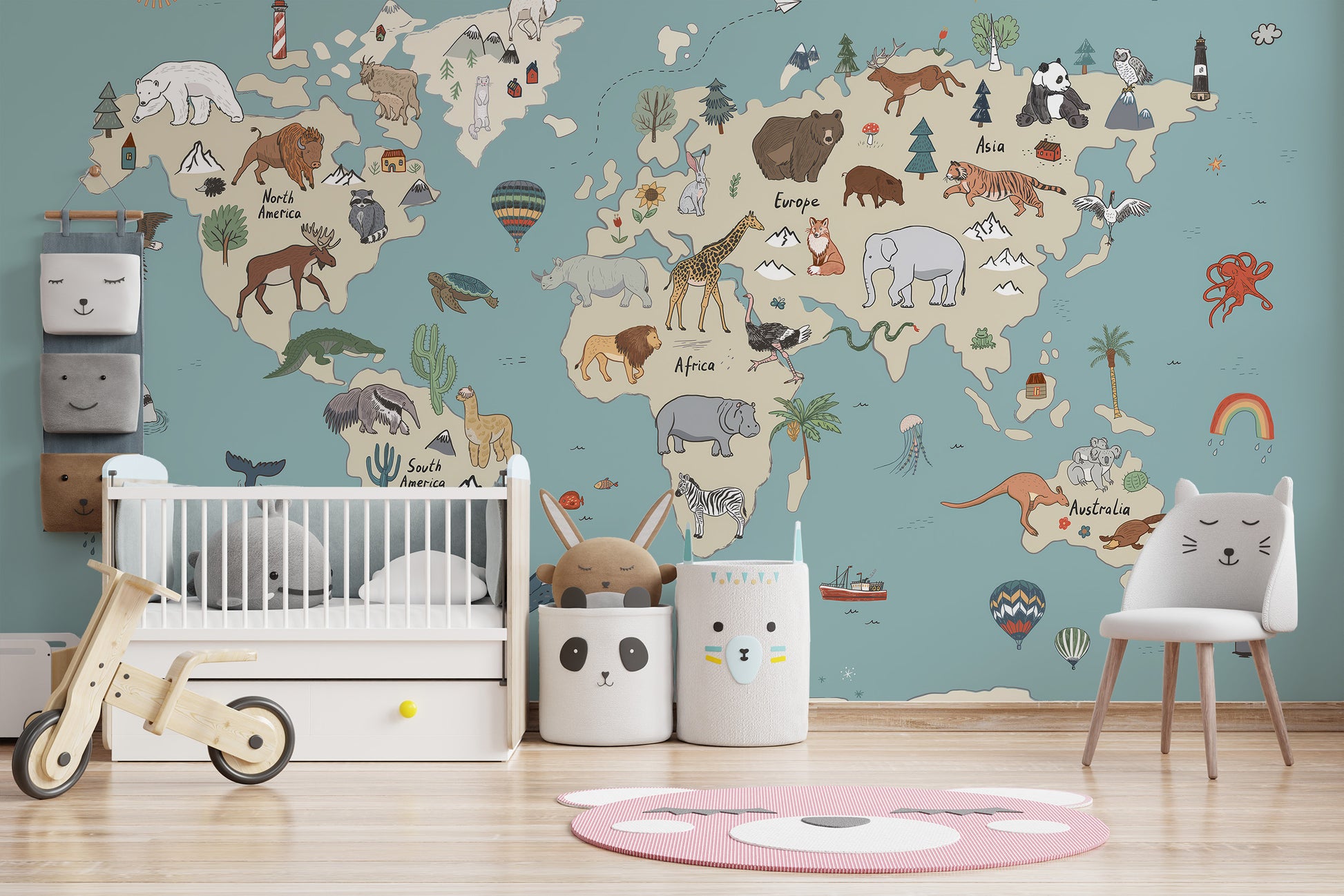 Animal Adventure Atlas wallpaper mural on a teal world map wall above a white crib and animal-face bins in a nursery