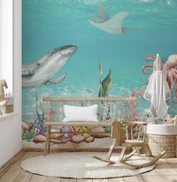 Aquatic Harmony wallpaper mural showing a gray whale and octopus over coral behind a wood crib bench in a nursery