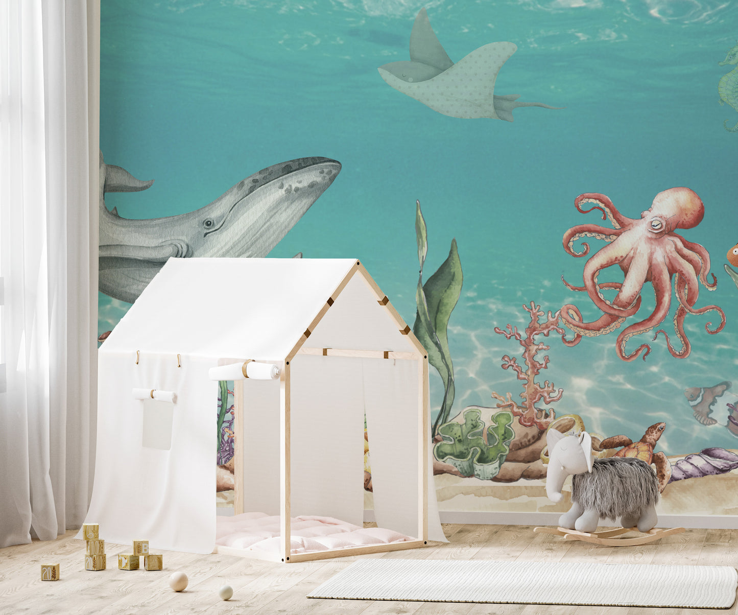Aquatic Harmony wallpaper mural of a whale, octopus and stingray in teal sea behind a white play tent in a kids room