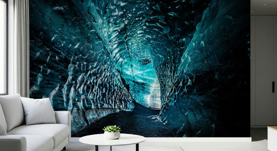 Arctic Cavern wallpaper mural of a glowing turquoise ice cave behind a white sofa in a modern living room