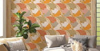 Art Nouveau Botanica Fan Flow Cosy Blooms wallpaper in warm orange florals behind a beige sofa and leafy plant