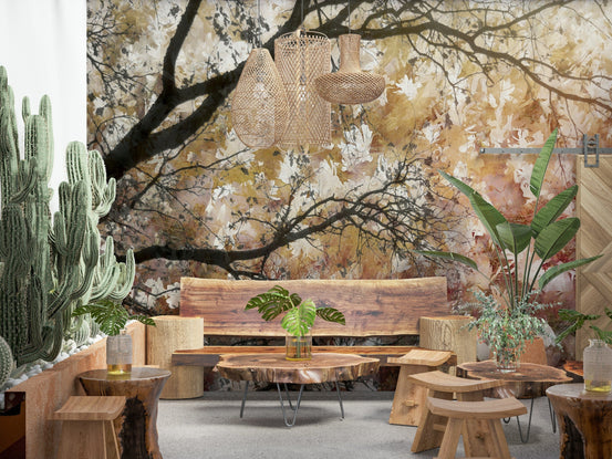 Autumnal Canopy wallpaper mural of golden leafy branches over a live-edge wood bench and cacti in a lounge