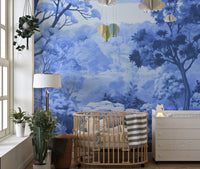 Watercolor Autumn Forest wallpaper mural in blue tones behind an oval rattan nursery crib and white dresser