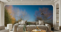 A photo-realistic wall mural of an autumn landscape in a light-filled room.

