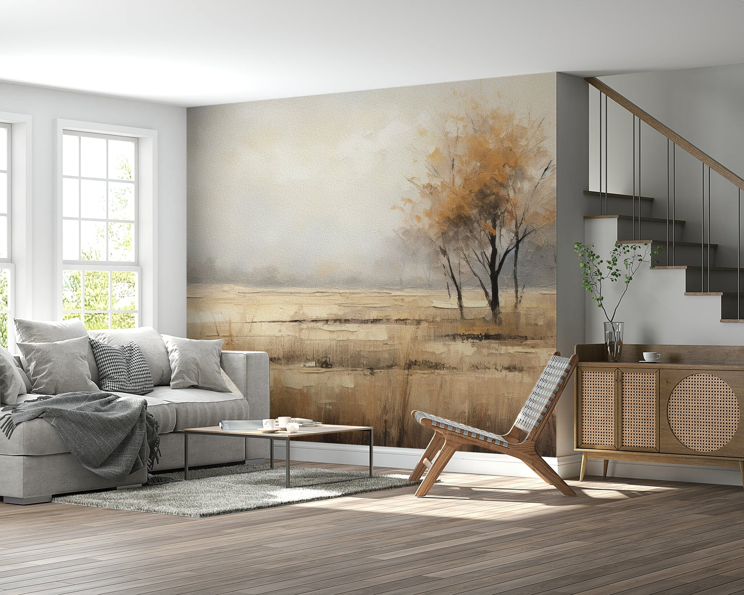 Autumn Vista wallpaper mural of a golden meadow and autumn tree behind a grey sofa and cane sideboard by a staircase