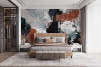Brushstroke Art wallpaper mural in orange and blue tones behind a camel leather bed with grey bedding in a bedroom