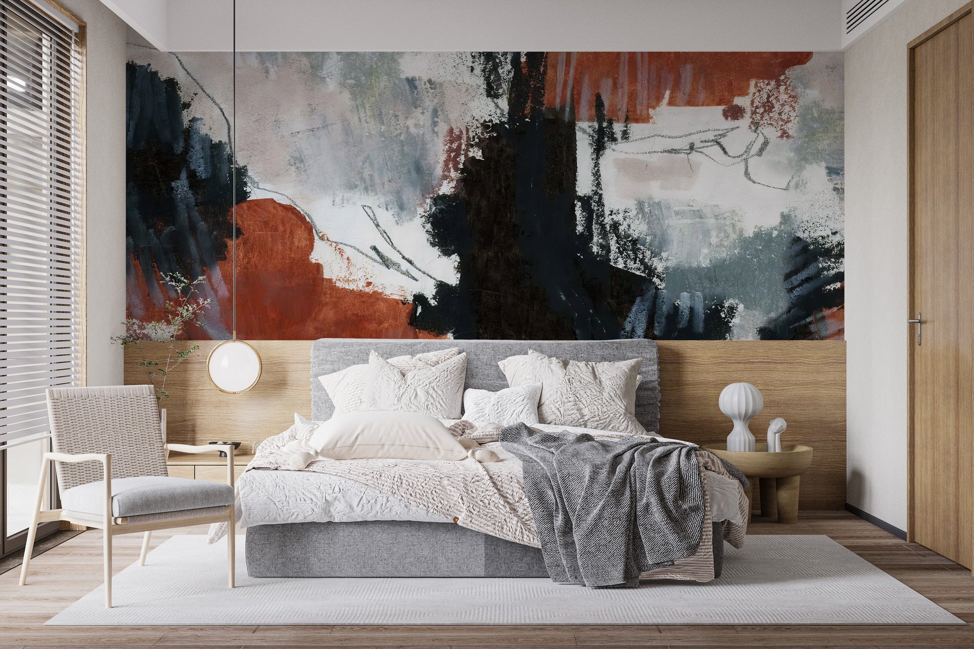 Brushstroke Art wallpaper mural with rust and navy strokes above a grey upholstered bed and rattan armchair in a bedroom